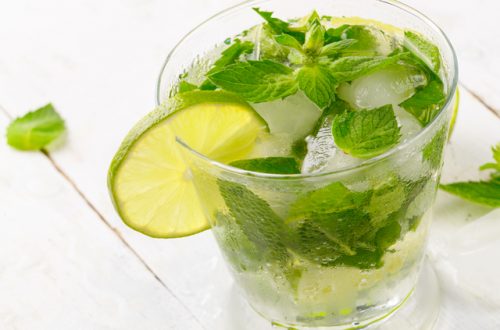 Fresh cold lime mojito on white table